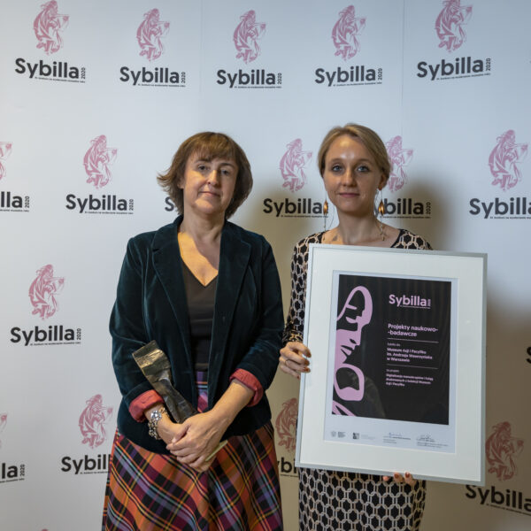 Obraz wpisu - Dwie kobiety na tle ścianki z napisami Sybilla 2020 i logo. Jedna trzyma w rękach statuetkę, druga spory dyplom w srebrnej ramie.